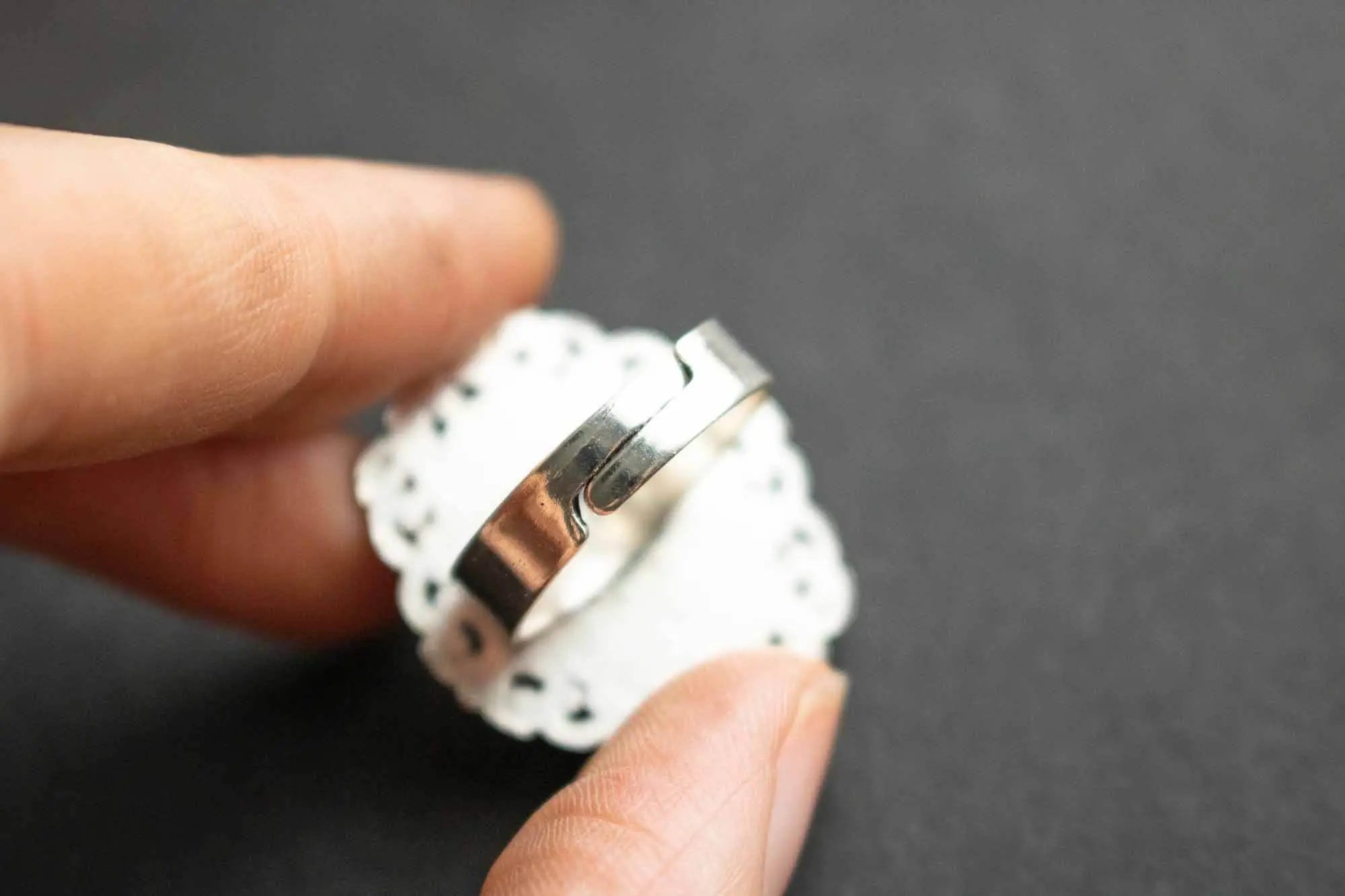 Bague en Onyx noire Hécate avec finition argentée sur un support en dentelle