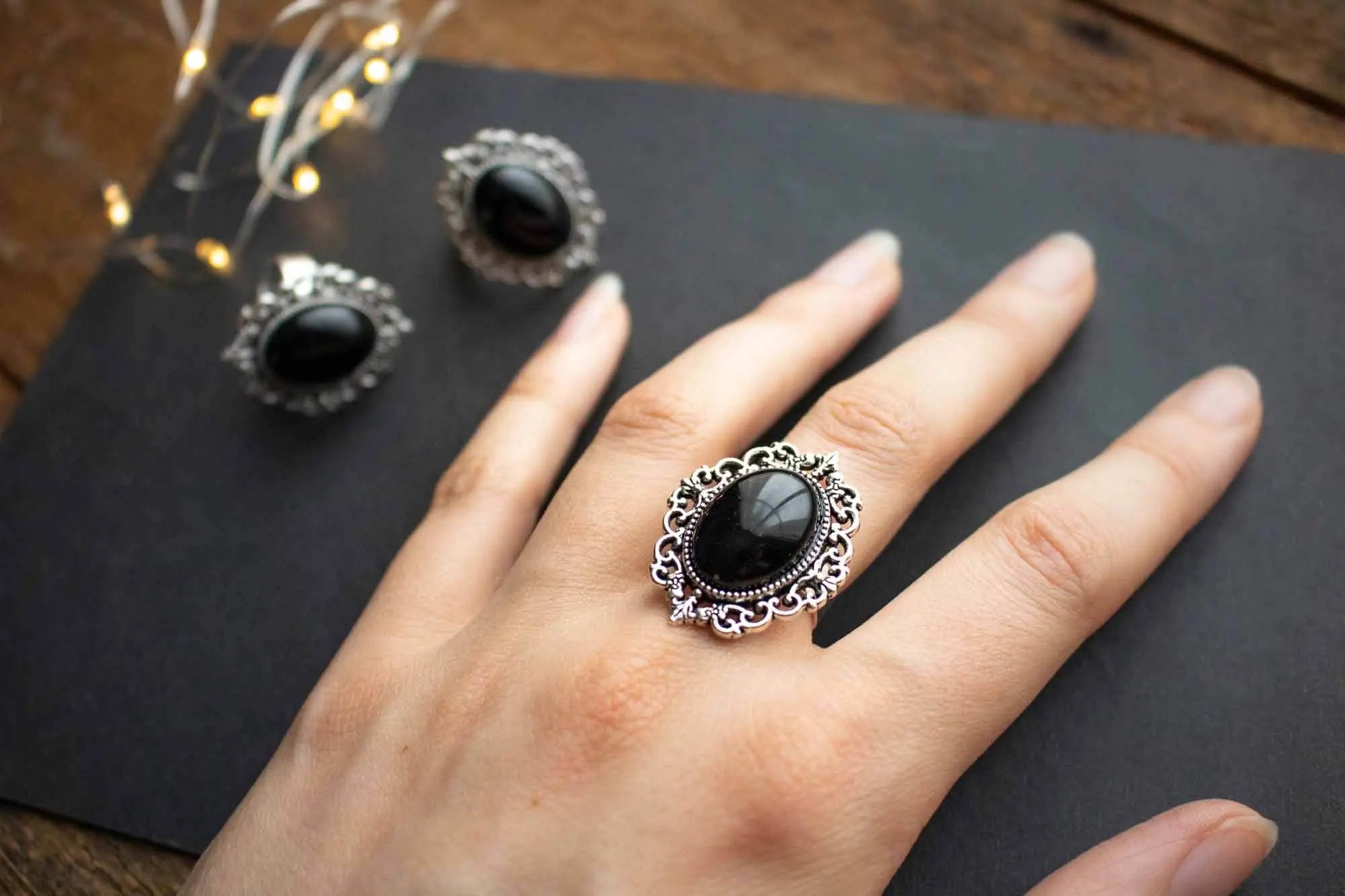 Bague en Onyx noire Hécate en argent avec un design vintage sur un doigt féminin