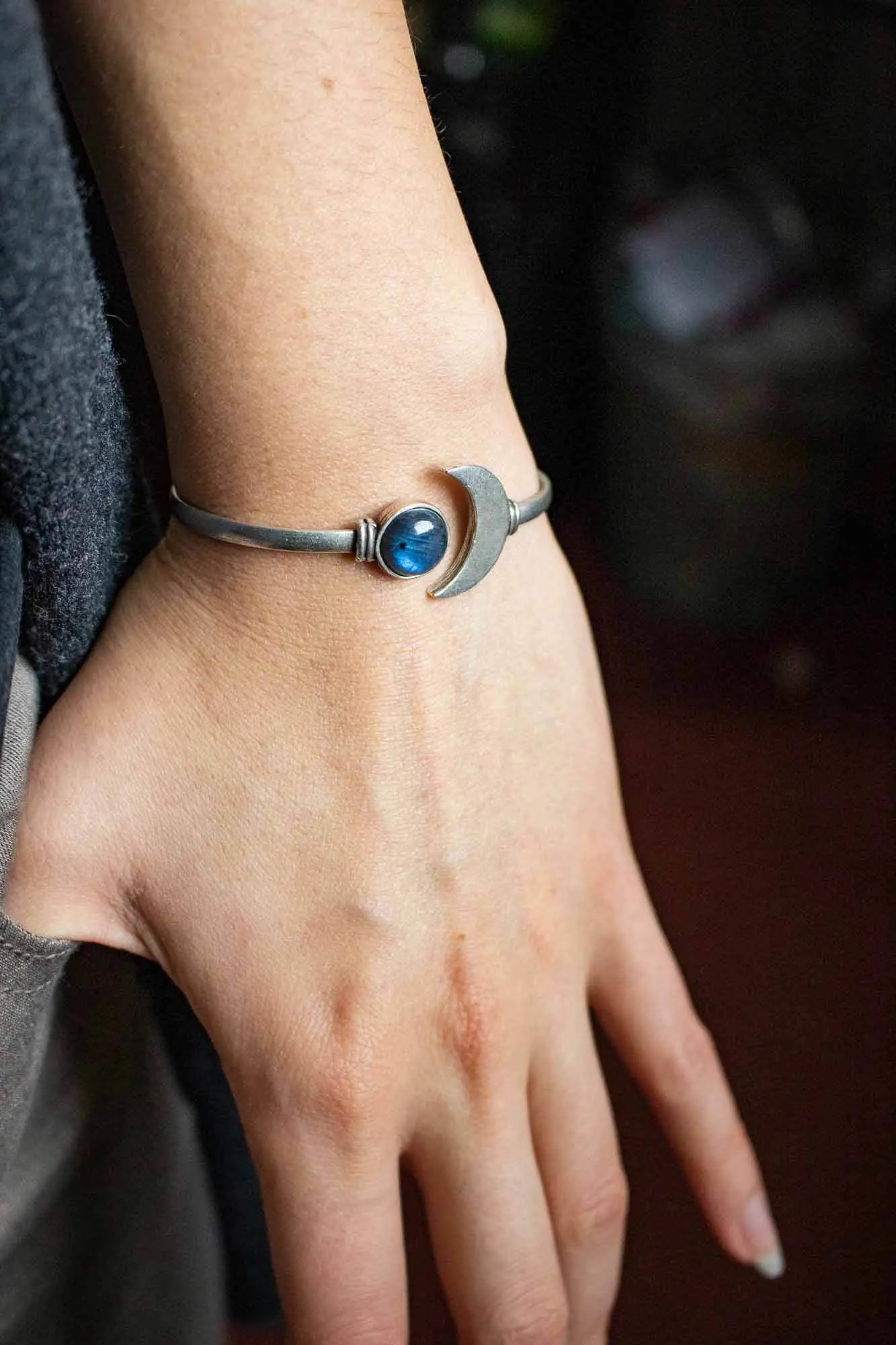 Bracelet manchette Lune et Labradorite en argent sur un poignet humain élégant