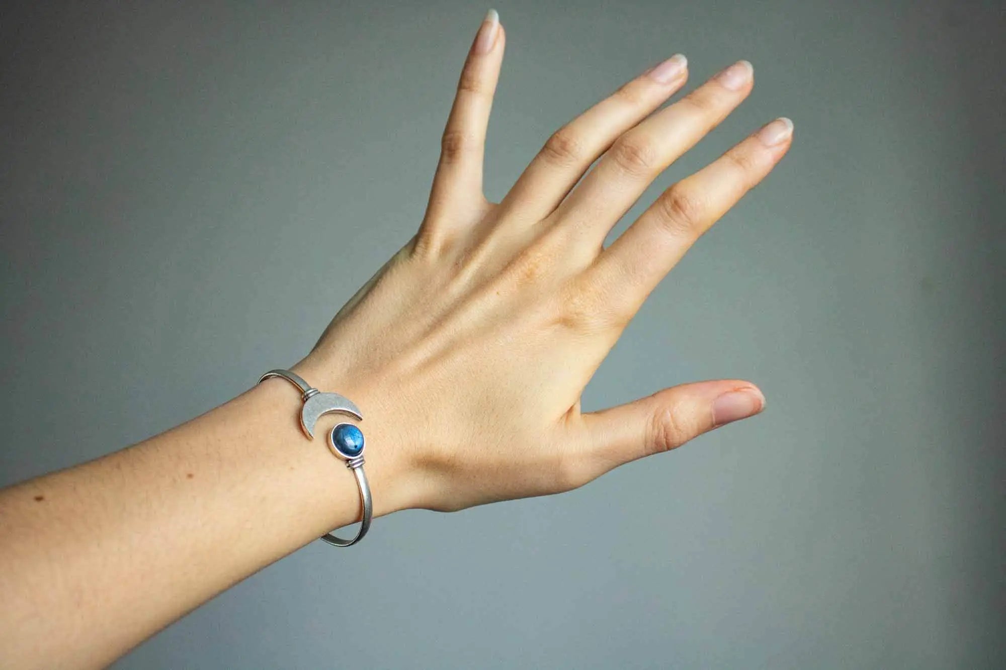 Bracelet manchette Lune et Labradorite porté sur un poignet féminin avec une surface lisse
