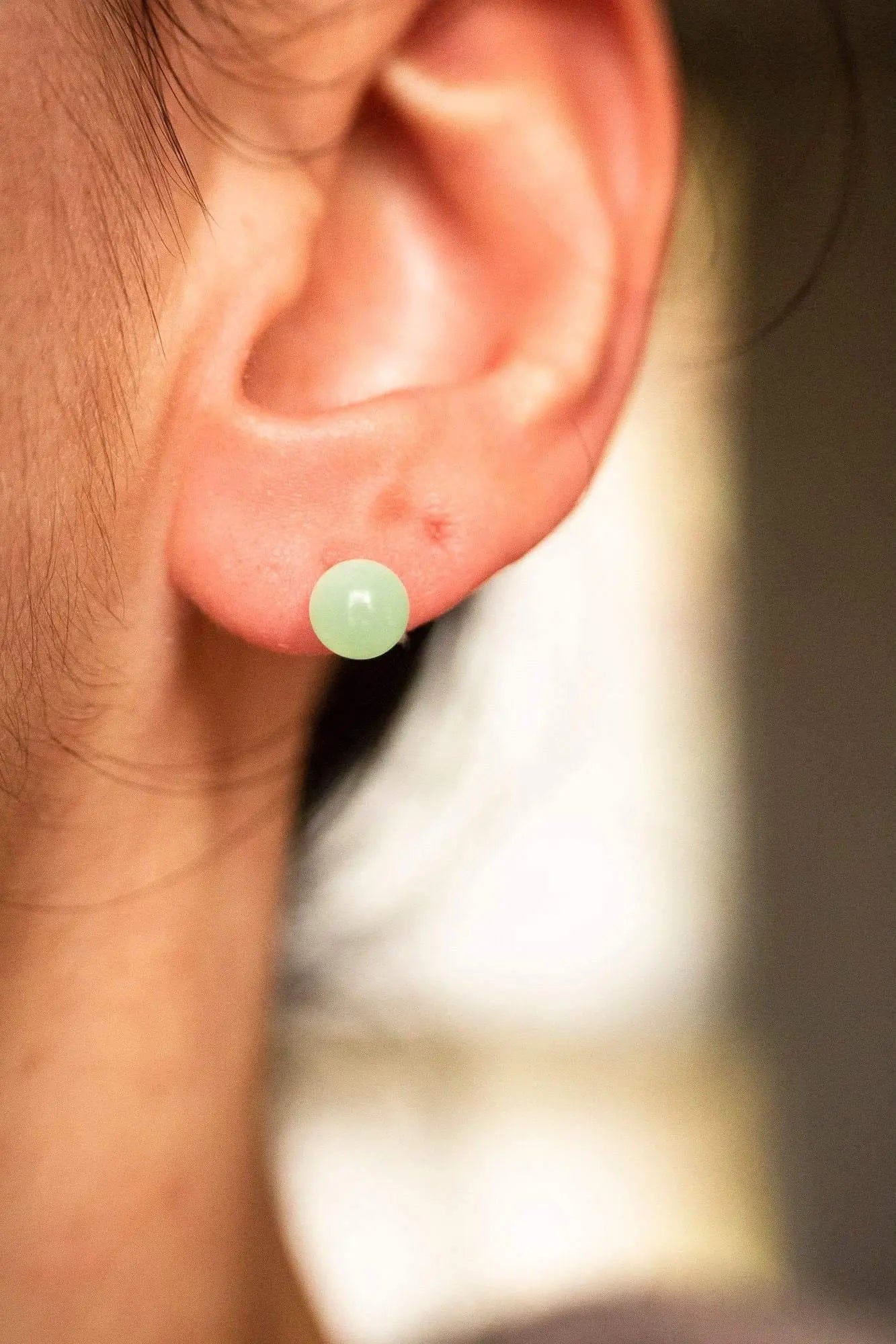 Boucles d'oreilles puce en Chrysoprase verte délicates, élégantes et modernes portées sur l'oreille