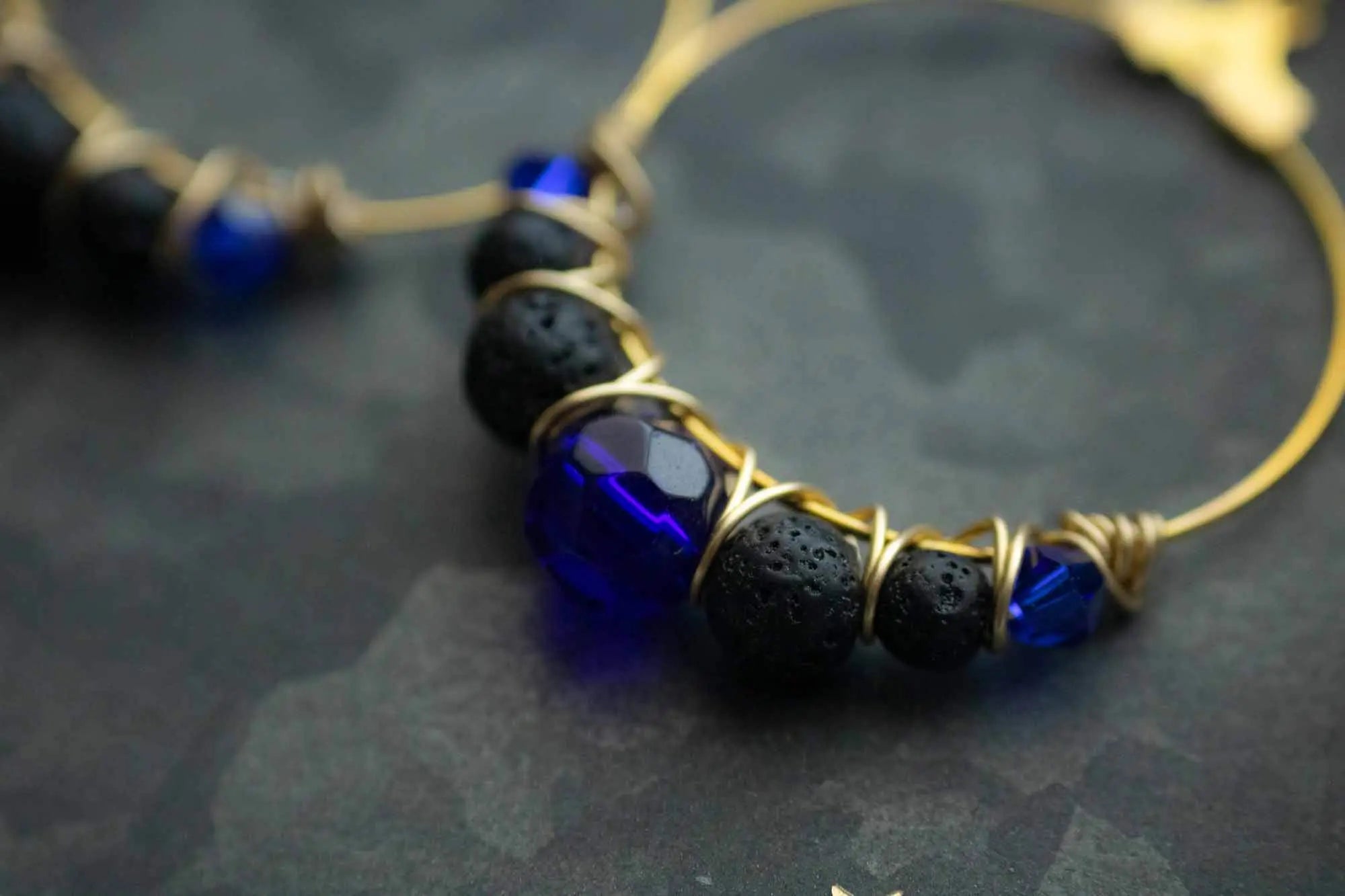 Boucles d&#39;oreilles dorées en pierre de lave noire et perles bleues lunamanashop