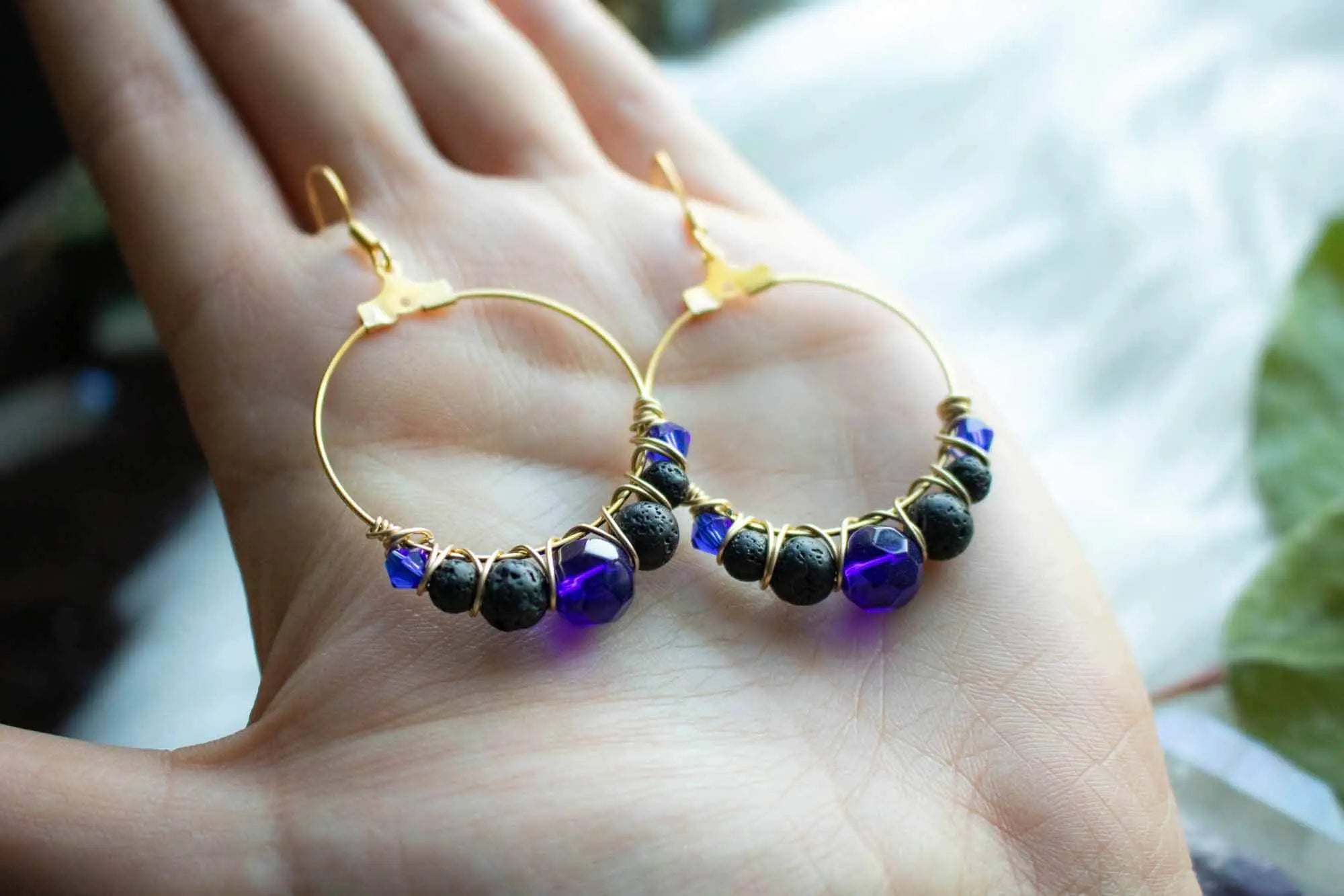 Boucles d&#39;oreilles dorées en pierre de lave noire et perles bleues lunamanashop
